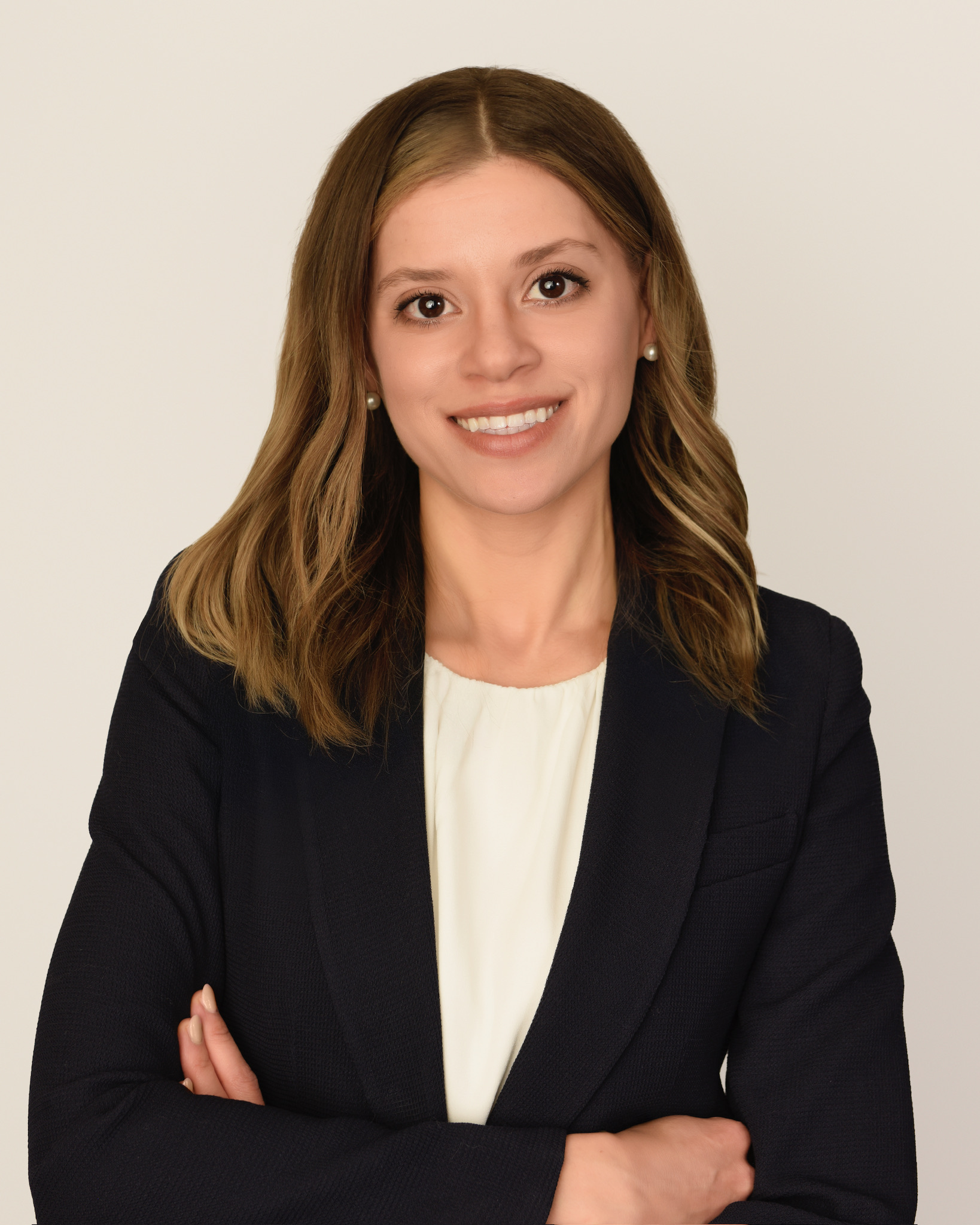 Woman in a dark blazer and light top against a neutral background in an Ottawa business headshot