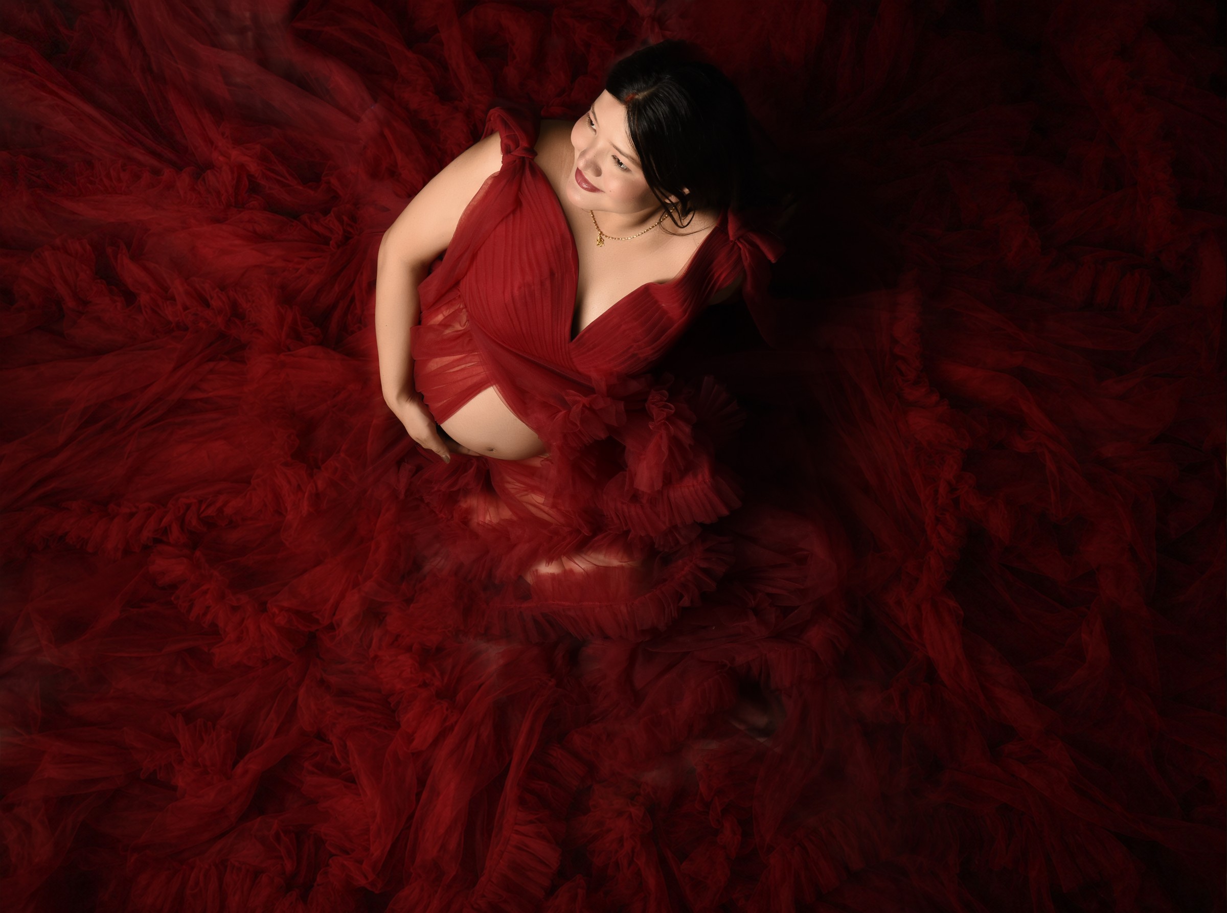 Maternity portrait with a flowing red gown