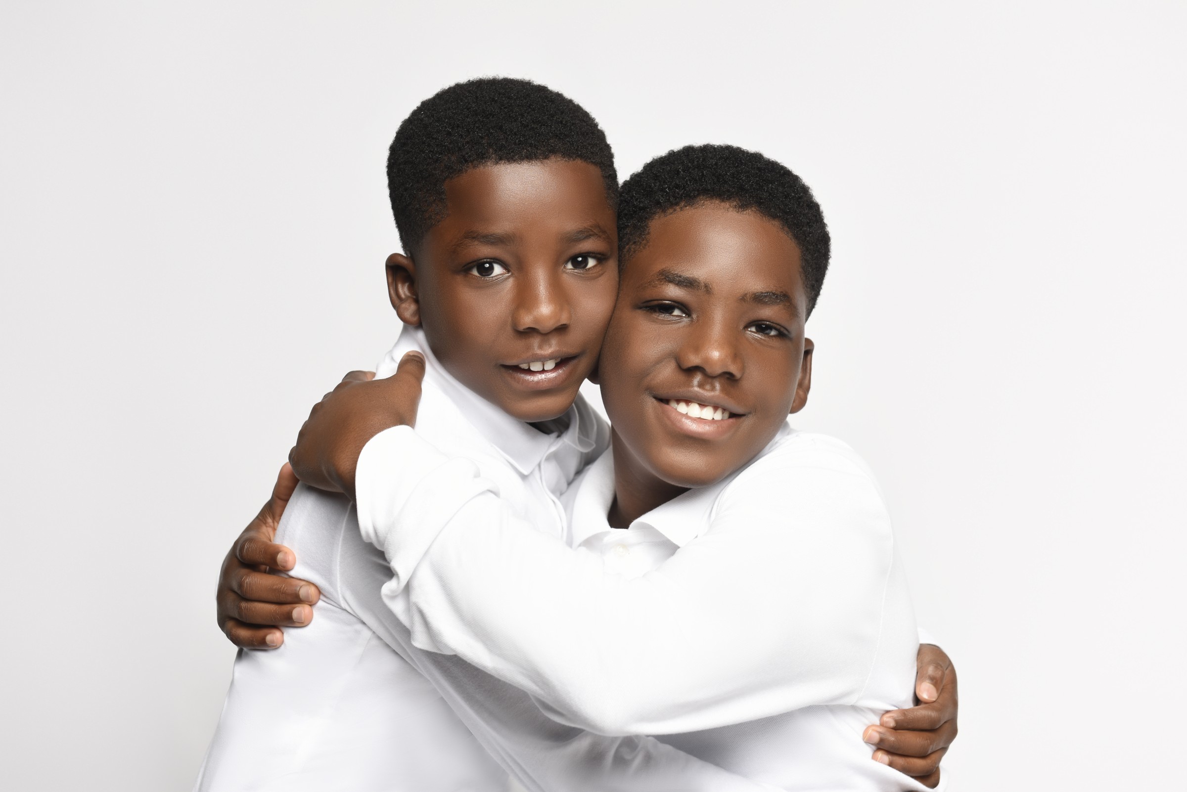 Two brothers embracing in white shirts